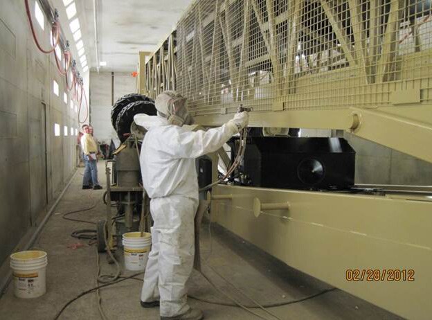 Zerust technician applying protective coating Technician spraying protective coating on indoor equipment